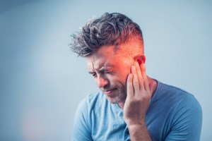 Man holding the side of his jaw in pain